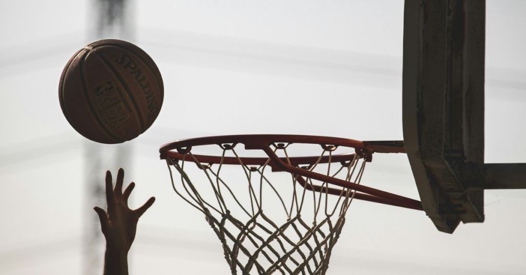 A hand attempting a layup into a basketball hoop